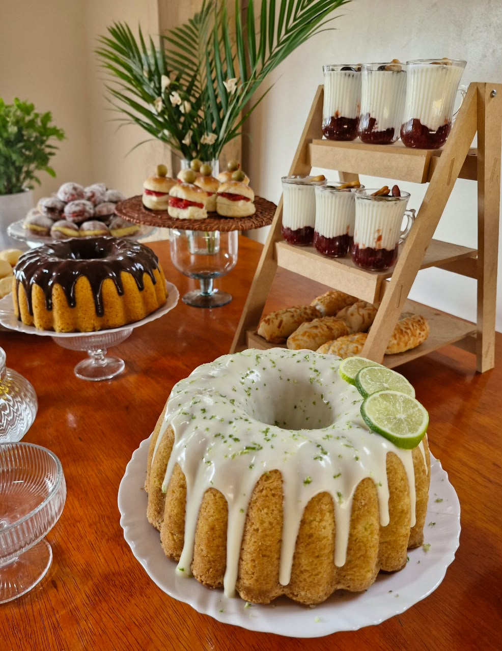 Bolo de limão com cobertura branca cercado de doces