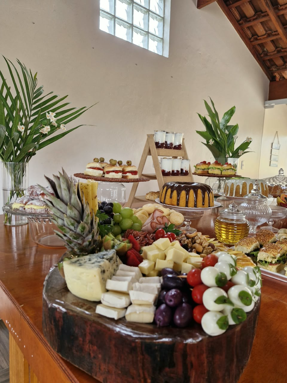 Mesa completa com tábuas de frios, frutas e salgados